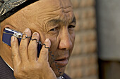 Uigur man talk to a mobile phone. Kashgar. Xinjiang province. China. Asia.