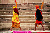 Two Hindu religious men walking along the ghat in Varanasi, India