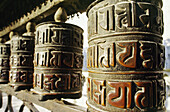 Worn heavy metal copper prayer wheels around a kora of a Bhudist temple, Tibet, China.