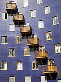 Pattern of windows and balconies on blue brick building in warehouse district of London, England.
