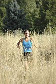 Woman running through field