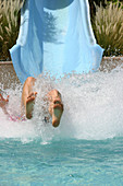Kid flying off water slide into a pool, Abu Dhabi, United Arab Emirates