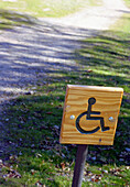 Disabled sign by road. Bosque de la Herrería, San Lorenzo del Escorial, Madrid, Spain