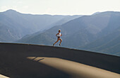 Woman running, Great Sand Dunes National Monument near Alamosa. Colorado, USA