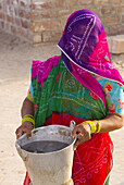 A veiled woman getting water from a well, Bishnoi tribal village, near Rohet, Rajasthan, India