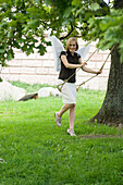 Mid adult woman wearing angel wings swinging