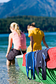 Zwei junge Frauen, Mädchen, sitzen auf einem Boot, Füße im Wasser, Walchensee, Oberbayern, Bayern, Deutschland