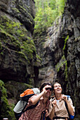 Paar wandert in der Partnachklamm, Mann schaut durch Fernglas, Garmisch-Partenkirchen, Bayern, Deutschland