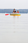 Father and daughter (3-4 years) in a dinghy on lake Ammersee, Bavaria, Germany