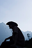 Man wearing cowboy hat chewing a blade of grass, Lenggries, Upper Bavaria, Bavaria, Germany