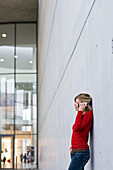 Frau mittleren Alters telefoniert mit einem Handy, Pinakothek der Moderne, München, Bayern, Deutschland