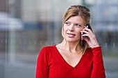 Middle aged woman talking on a mobile phone, Pinakothek der Moderne, Munich, Bavaria, Germany