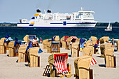 Beach chairs at beach, ferry in background, Travemunde, Lubeck, Schleswig-Holstein, Germany