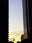 Sunset on the Upper West Side of Manhattan, with residentail buildings in the foreground, and the sunseting in the background. USA