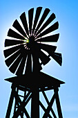 Outline of rural windmill against blue sunny sky