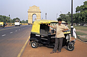 Rickshaw driver with India Gate in background, New Delhi. India