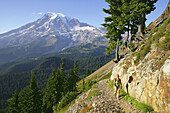 Female hiker on trail to Pinnacle Pass with Mt. Rainier looming in the background, Mt. Rainier National Park, Washington, USA