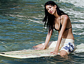 Mädchen auf Surfbrett im Wasser