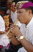 A Balinese musician plays a flute. Ubud. Bali. Indonesia.