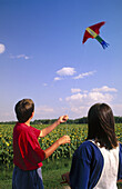 boy and girl flying a kite together