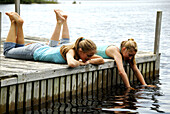 girl 13, girl 18 laying on dock together