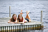 sisters 13 and 18 yrs laying on dock together