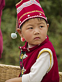 little Bai boy in red at market, Dali, China