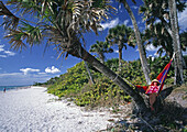 Senior woman lounging in a hammock in palms at Casperson beach in SW Florida (USA)