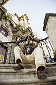 Smoking cigar in the stairs of the cathedral. Havana. Cuba.