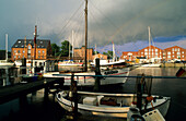 Boote im Hafen von Orth unter grauen Wolken, Insel Fehmarn, Schleswig-Holstein, Deutschland, Europa