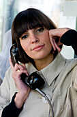Junge Frau telefoniert in öffentlicher Telefonzelle, Düsseldorf, Nordrhein-Westfalen, Deutschland