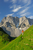 young woman hiking at notch Binssattel with Lamsenspitze and Schafkarspitze in background, Karwendel range, Tyrol, Austria