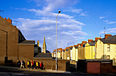 Fussgänger und Häuser in einer Strasse in der Bogside, Derry, County Londonderry, Irland, Europa