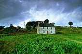 Altes Cottage auf grüner Wiese, County Mayo, Irland, Europa