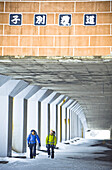 Two men walking through a pedestrian underpass in winter, Hokkaido, Japan, Asia