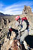 Paar beim Klettern auf einem Grat im Teide Nationalpark, Teneriffa, Kanarische Inseln, Spanien