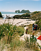 Frau und Kinder wandern zum Strand, Wharariki Beach, Nordwestküste, Südinsel, Neuseeland