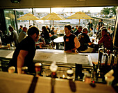 Blick über die Theke auf Menschen in der Bar der Segler am Abend, Viaduct Harbour, Auckland, Nordinsel, Neuseeland