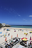 Leute sonnen sich am Porthminster Beach, St. Ives, Cornwall, England, Großbritannien