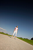 Woman standing on road, Munsing, Bavaria, Germany