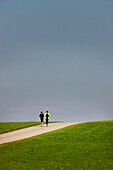 Paar joggt über Landstraße, Münsing, Bayern, Deutschland