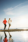 Couple jogging along lake Starnberg, Ambach, Bavaria, Germany