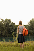 Junges Mädchen mit einer Decke steht an einem Baggersee, Freising, Bayern, Deutschland