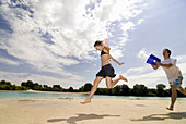 Teenage boy with bucket of water running after girlfriend, Freising, Bavaria, Germany