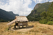 Thatched hut in the fields under cloudy sky, Luang Prabang province, Laos