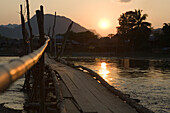 Sunset over wooden bridge over the river Nam Xong, Vang Vieng, Vientiane Province, Laos