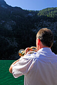 Mann spielt auf Flügelhorn, Echo am Königssee, Berchtesgadener Alpen, Nationalpark Berchtesgaden, Berchtesgaden, Oberbayern, Bayern, Deutschland