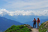 couple on trail above valley of Maria Alm with view to Hohe Tauern range, Steinernes Meer range, Berchtesgaden range, Salzburg, Austria