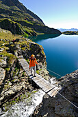 Junge Frau auf Hängebrücke, Klettersteig am Wangenitzsee, Schobergruppe, Hohe Tauern, Nationalpark Hohe Tauern, Kärnten, Österreich