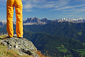 junge Frau auf Felsabsatz stehend mit Blick in die Dolomiten mit Geislergruppe und Sella, Radlseehütte, Sarntaler Alpen, Südtirol, Italien